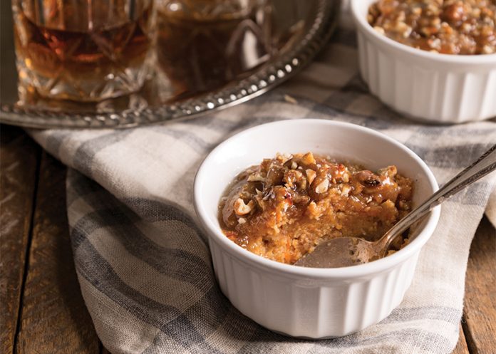 Sweet Potato Cornbread Pudding with Bourbon Sauce on linen with spoon
