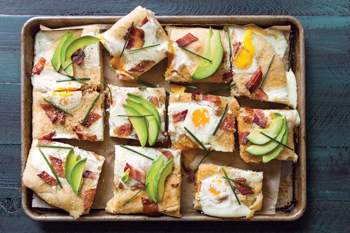 Bacon and Egg Focaccia sliced on sheet pan with green surface