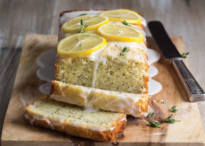 Glazed Lemon-Thyme Poppy Seed Cake sliced on cutting board