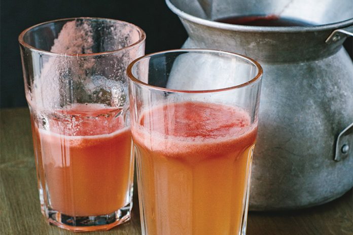 Fresh Tomato Juice in glasses with silver pitcher