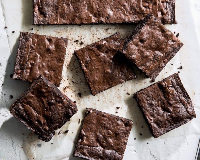 Black Cocoa Brownies stacked on parchment baking recipe