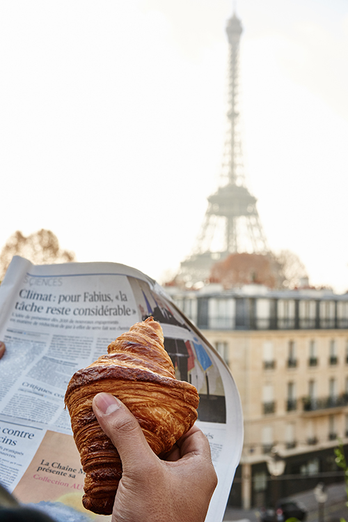 guest enjoying a croissant while viewing the Eiffel Tower