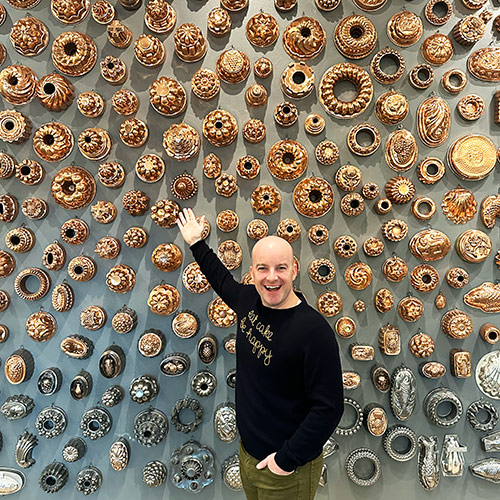 Brian in front of a wall of bundt pans