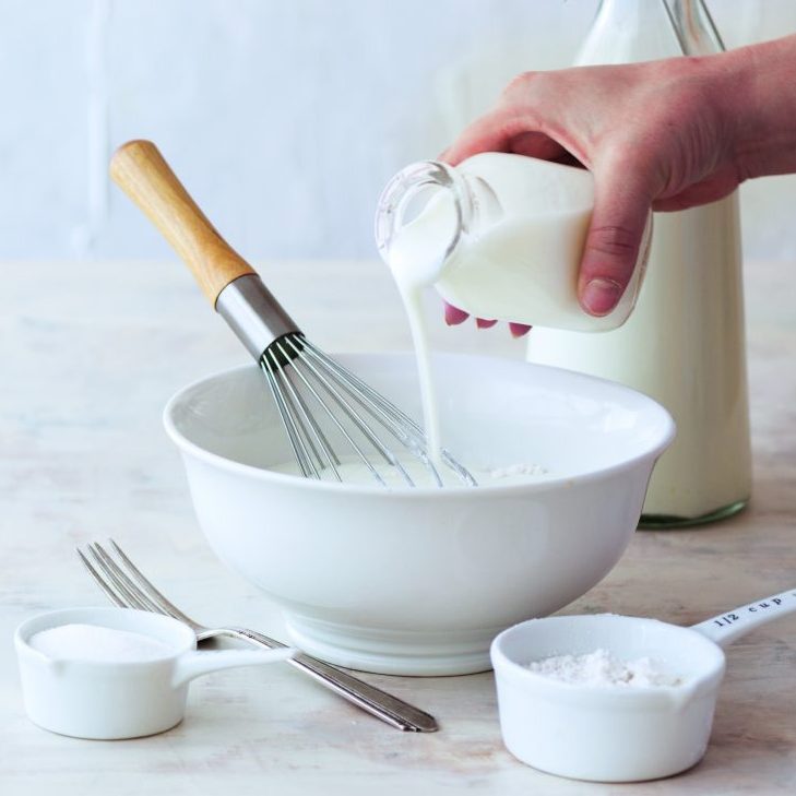 buttermilk being poured into white bowl